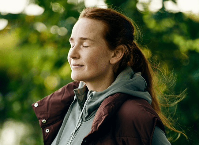 Kvinne med lukkede øyne, slapper av utendørs